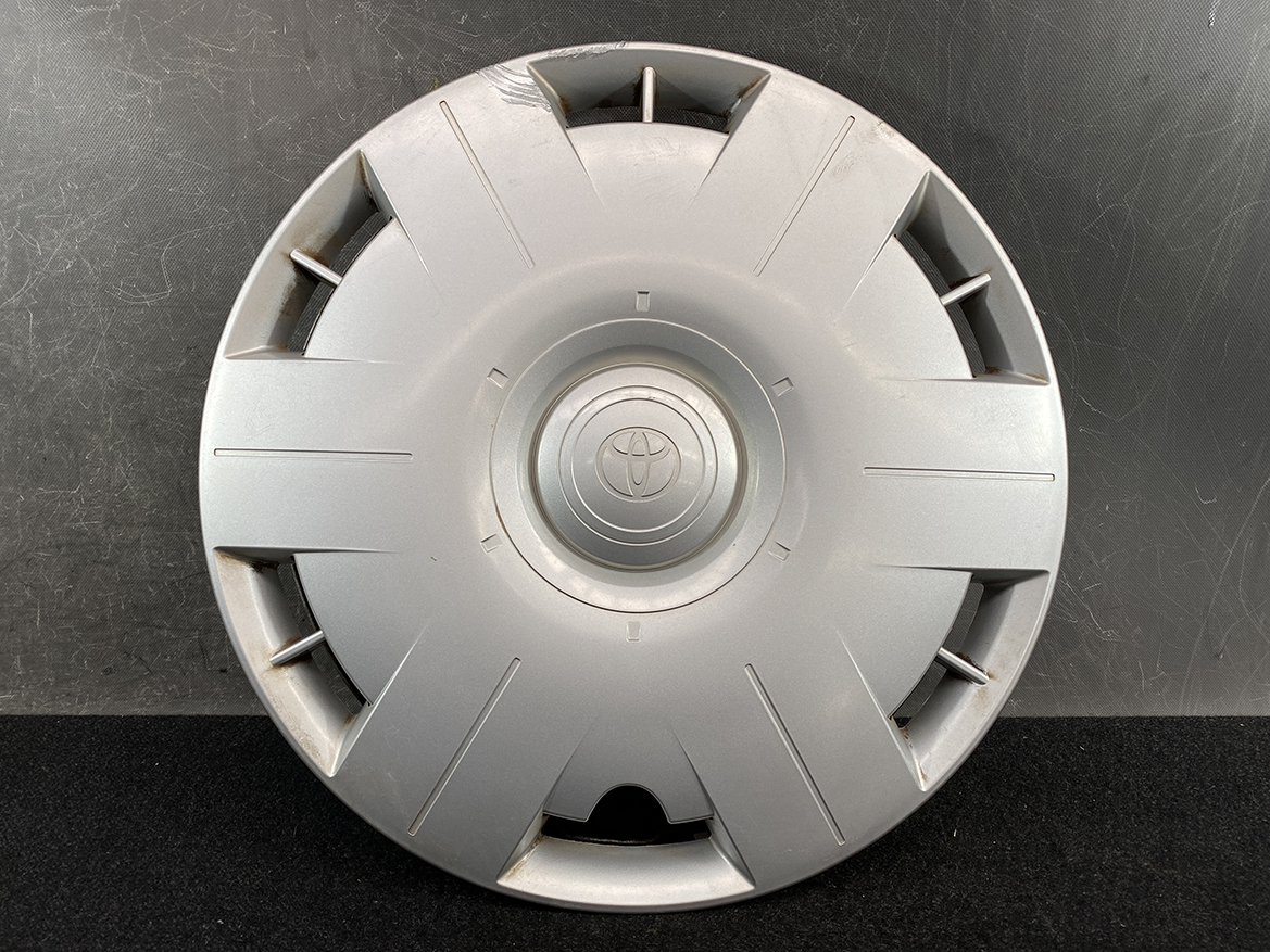 B413_2 TOYOTA VOXY ZWR80 Genuine 15inch WHEEL CAP / HUB CAP 2595 x1 » NZ.95 » JDM-PARTS NZ » JDM-PARTS NZ Silver Toyota hubcap laid flat with a central Toyota emblem and radiating grooves against a dark background. TOYOTA VOXY ZWR80 Genuine 15inch WHEEL CAP / HUB CAP 2595 x1 » JDM-PARTS NZ
