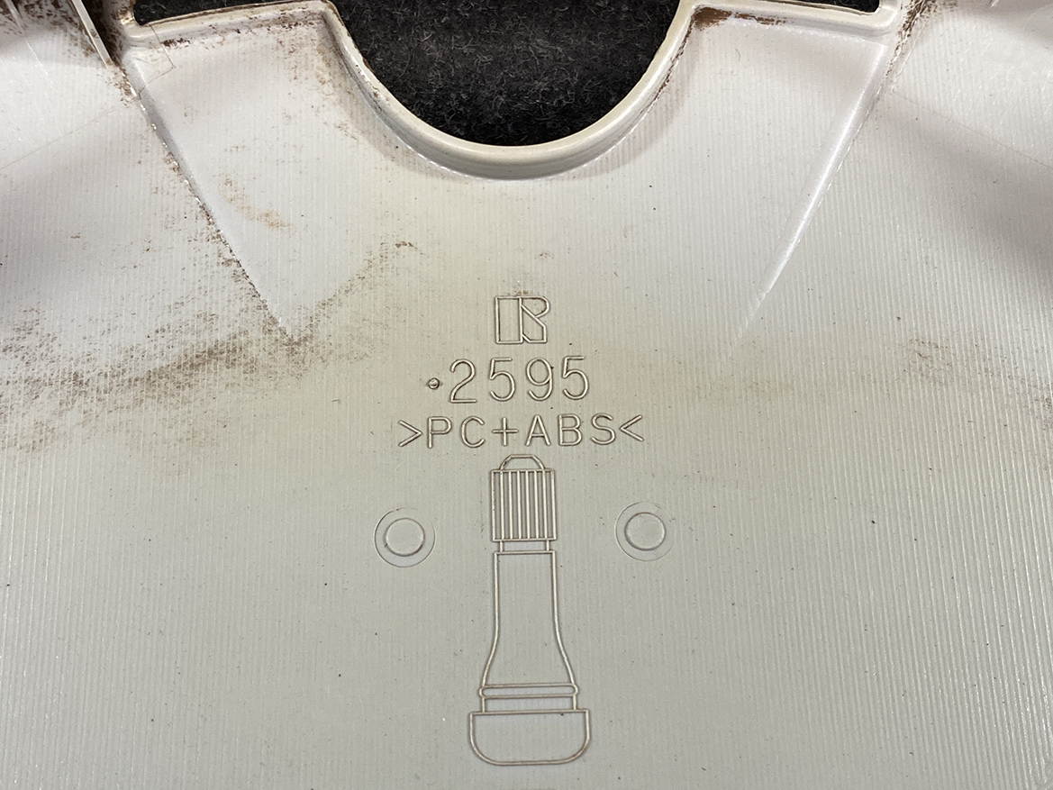 B413_4 TOYOTA VOXY ZWR80 Genuine 15inch WHEEL CAP / HUB CAP 2595 x1 » NZ.95 » JDM-PARTS NZ » JDM-PARTS NZ Close-up of a light gray plastic panel showing the material code PC+ABS, a part number 0.2595, and a bottle icon with two circular holes nearby. TOYOTA VOXY ZWR80 Genuine 15inch WHEEL CAP / HUB CAP 2595 x1 » JDM-PARTS NZ