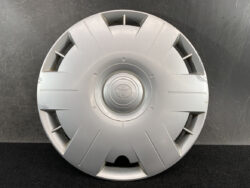 Round silver Toyota hubcap with central emblem, photographed against dark backdrop (car wheel cover).