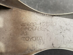 Embossed Toyota part label: 42602-52540, PC+ABS, A1, on a dusty automotive plastic component