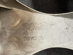 Close-up of a car part with engravings: 42602-52540, PC+ABS, A1, TOYOTA.