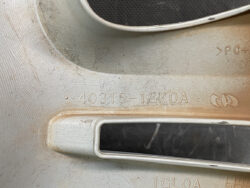 Close-up of a worn metal car part with stamped part number 40315-1GK0A and a rectangular slot/opening nearby.