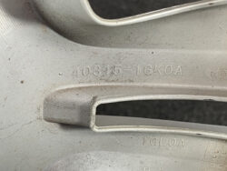 Close-up of a dusty gray car wheel rim showing the stamped code 40315-1GK0A.