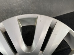 Close-up of a silver alloy car wheel rim with visible scratches and scuffs on the surface area.