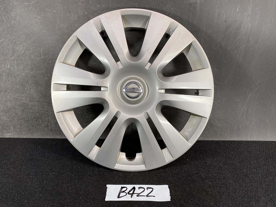 B422_1 NISSAN Genuine 15inch WHEEL CAP / HUB CAP 40315-1GK0A x1 » NZ.95 » JDM-PARTS NZ » JDM-PARTS NZ Silver Nissan hubcap with 12 spokes and a central Nissan emblem, resting on a dark surface. NISSAN Genuine 15inch WHEEL CAP / HUB CAP 40315-1GK0A x1 » JDM-PARTS NZ