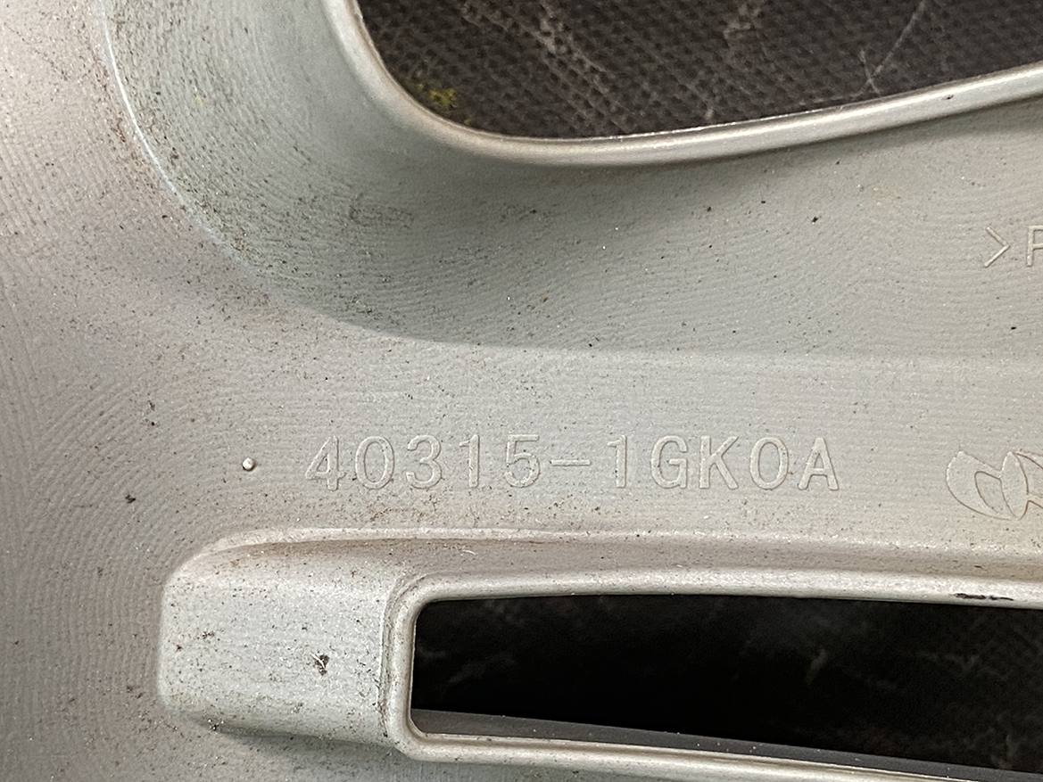 B422_4 NISSAN Genuine 15inch WHEEL CAP / HUB CAP 40315-1GK0A x1 » NZ.95 » JDM-PARTS NZ » JDM-PARTS NZ Close-up of a silver metal surface with the stamped code 40315-1GK0A on it, near a recessed opening. NISSAN Genuine 15inch WHEEL CAP / HUB CAP 40315-1GK0A x1 » JDM-PARTS NZ