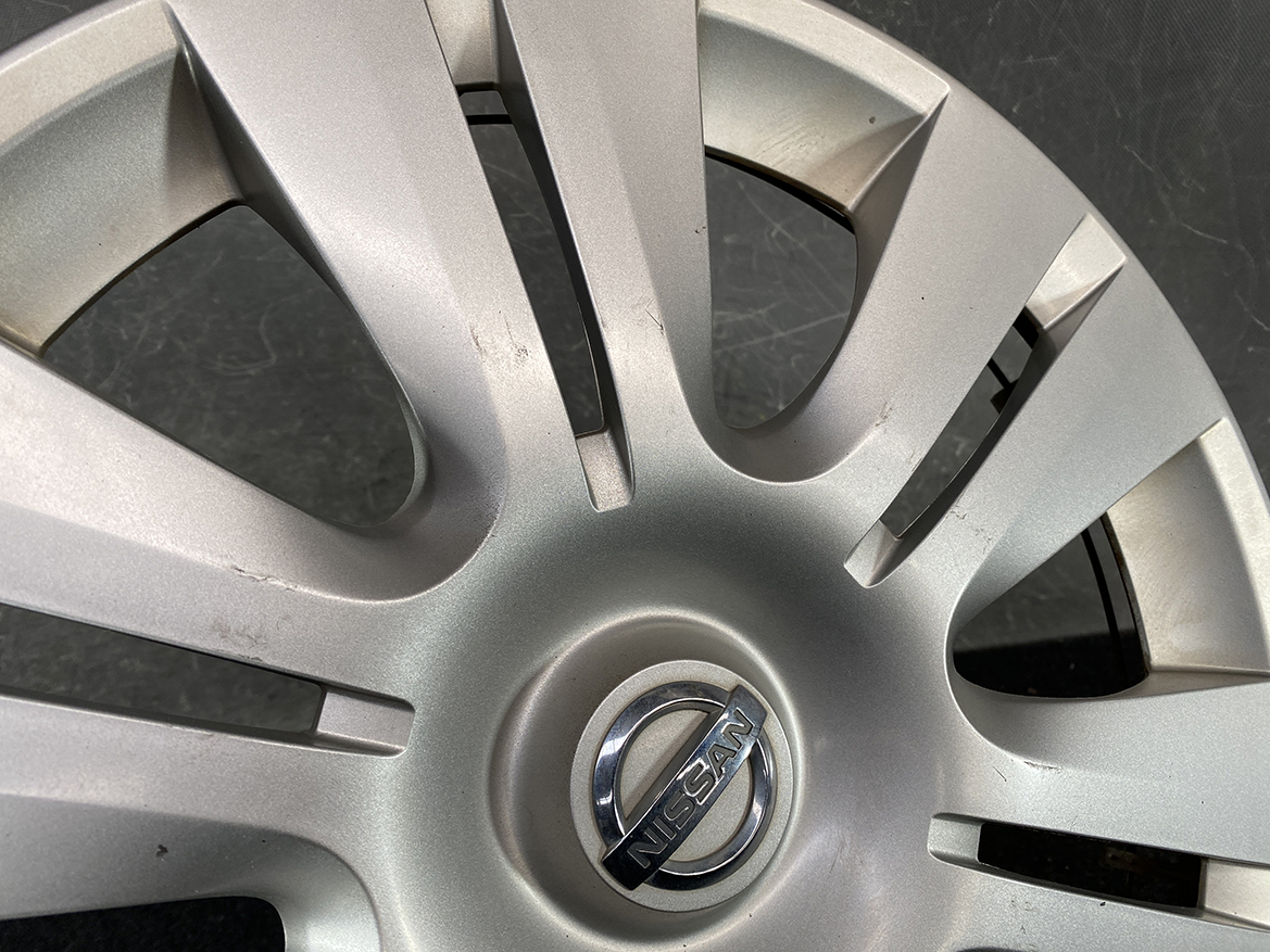 B422_5 NISSAN Genuine 15inch WHEEL CAP / HUB CAP 40315-1GK0A x1 » NZ.95 » JDM-PARTS NZ » JDM-PARTS NZ Close-up of a silver Nissan hubcap with scratches and scuffs on the surface around the emblem. NISSAN Genuine 15inch WHEEL CAP / HUB CAP 40315-1GK0A x1 » JDM-PARTS NZ
