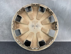 Circular beige car wheel cover viewed from inside, showing mounting clips around the rim and central hub area