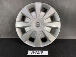 Silver Nissan hubcap with a multi-spoke design and central Nissan badge on a dark surface NISSAN TIIDA C11 Genuine 15inch WHEEL CAP / HUB CAP 40315 ED000 x1 » JDM-PARTS NZ
