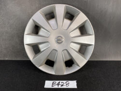 Silver Nissan hubcap with a multi-spoke design laid on a dark surface, centered by the Nissan emblem. NISSAN TIIDA C11 Genuine 15inch WHEEL CAP / HUB CAP 40315 ED000 x1 » JDM-PARTS NZ