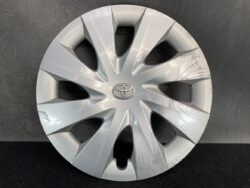 Silver Toyota hubcap with multiple visible scratches on the right and bottom edges.