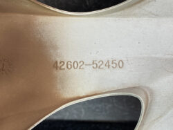 Close-up of a copper-toned alloy wheel rim with stamped part number 42602-52450.