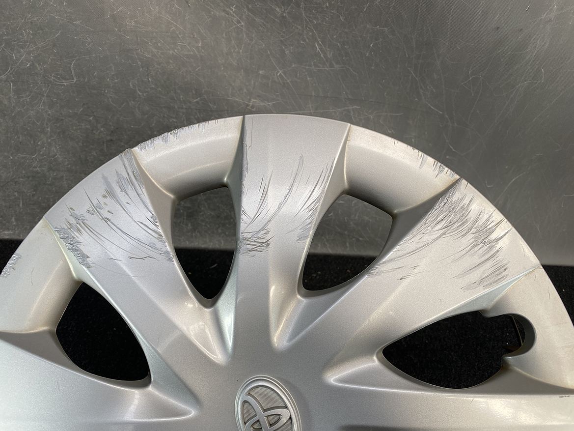 B433_6 TOYOTA PORTE / SPADE Genuine 15inch WHEEL CAP / HUB CAP 42602-52450 x1 » NZ.95 » JDM-PARTS NZ » JDM-PARTS NZ Silver car wheel cover with deep scratches across the spokes and around the rim. TOYOTA PORTE / SPADE Genuine 15inch WHEEL CAP / HUB CAP 42602-52450 x1 » JDM-PARTS NZ