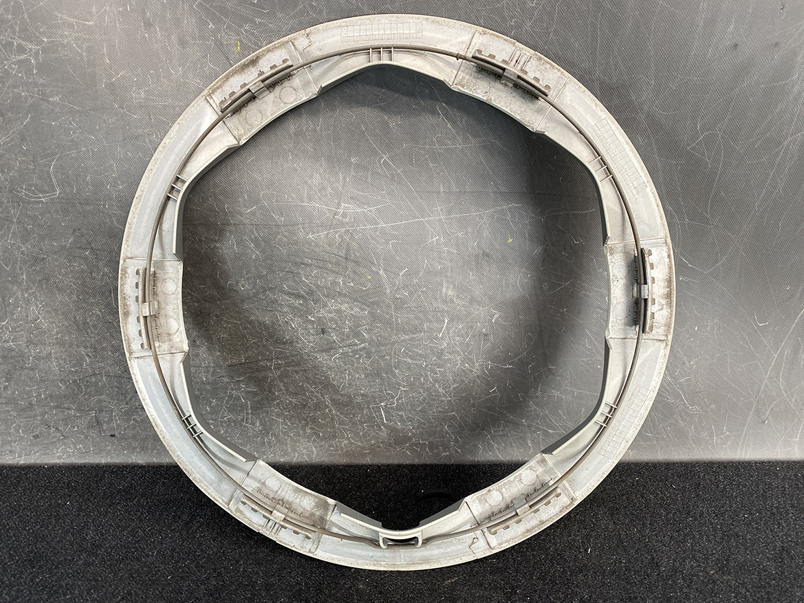 B434_3 TOYOTA PRIUS NHW20 Genuine 15inch WHEEL CAP / HUB CAP x1 » NZ.95 » JDM-PARTS NZ » JDM-PARTS NZ Circular gray plastic frame with inner rails and small latches, resting on a dark textured surface. TOYOTA PRIUS NHW20 Genuine 15inch WHEEL CAP / HUB CAP x1 » JDM-PARTS NZ