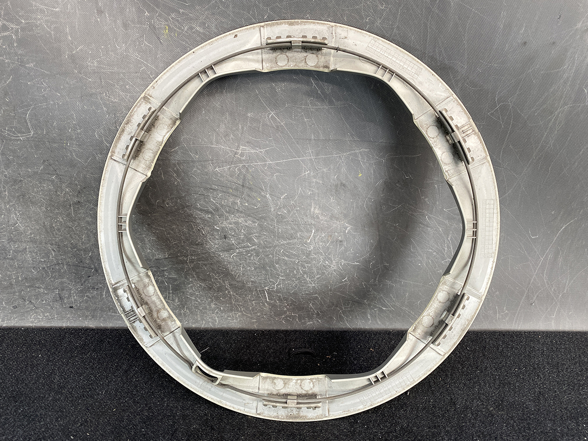 B435_3 TOYOTA PRIUS NHW20 Genuine 15inch WHEEL CAP / HUB CAP x1 » NZ.95 » JDM-PARTS NZ » JDM-PARTS NZ Circular gray plastic ring with embedded metal rails, placed on a scratched dark surface. TOYOTA PRIUS NHW20 Genuine 15inch WHEEL CAP / HUB CAP x1 » JDM-PARTS NZ