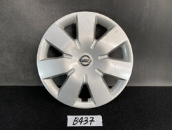 Silver Nissan hubcap with a multi-spoke design and central Nissan logo on a dark surface.
