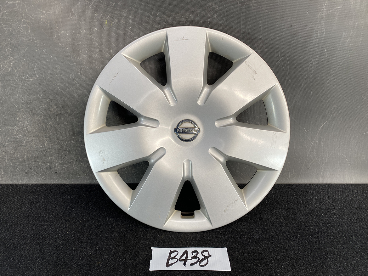 B438_1 NISSAN NOTE E11 Genuine 14inch WHEEL CAP / HUB CAP x1 40315 1U600 x1 » NZ.95 » JDM-PARTS NZ » JDM-PARTS NZ Silver Nissan hubcap with an eight-spoke design and center emblem, resting on a dark surface with minor scratches. NISSAN NOTE E11 Genuine 14inch WHEEL CAP / HUB CAP x1 40315 1U600 x1 » JDM-PARTS NZ