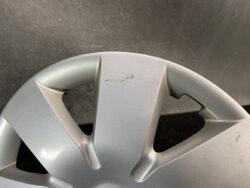Silver alloy wheel with a small scratch on the spoke hub area.