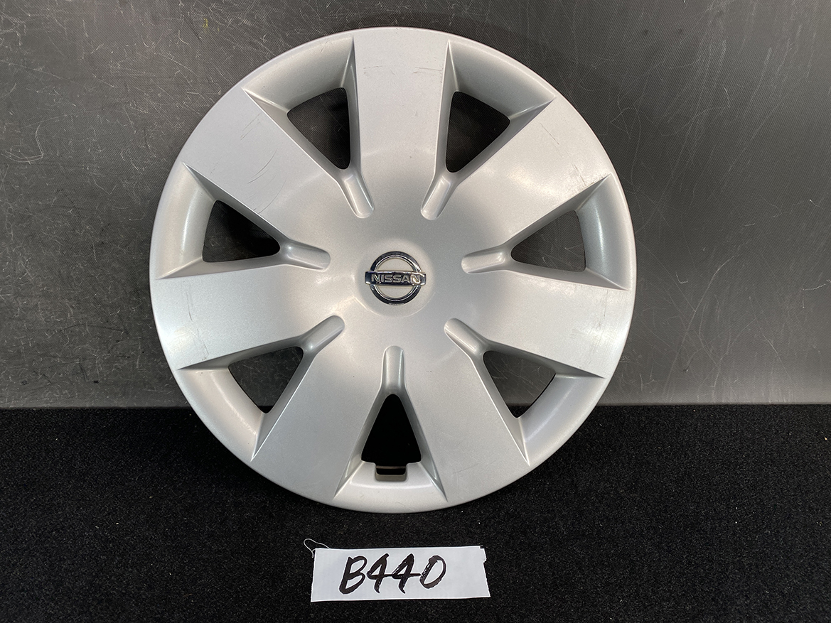 B440_1 NISSAN NOTE E11 Genuine 14inch WHEEL CAP / HUB CAP x1 40315 1U600 x1 » NZ.95 » JDM-PARTS NZ » JDM-PARTS NZ Silver Nissan wheel cover with eight spokes and a central Nissan badge, shown on a dark surface. NISSAN NOTE E11 Genuine 14inch WHEEL CAP / HUB CAP x1 40315 1U600 x1 » JDM-PARTS NZ