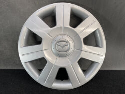 Silver Mazda hubcap with seven-spoke design and central Mazda emblem