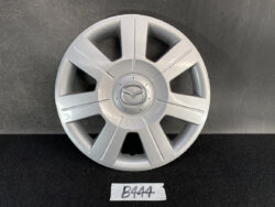Silver alloy wheel hubcap with eight spokes and a Mazda emblem in the center.