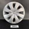 Silver Toyota wheel hubcap with central emblem, resting against a dark backdrop with visible scratches on the rim. MAZDA DEMIO DY3W Genuine 14inch WHEEL CAP / HUB CAP x1 » JDM-PARTS NZ