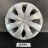 Silver Toyota hubcap with a multi-spoke design and centered Toyota emblem on a dark surface. TOYOTA VITZ Yaris Genuine 14inch WHEEL CAP / HUB CAP x1 » JDM-PARTS NZ
