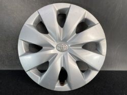 Silver Toyota hubcap wheel cover with central emblem, showing 5-spoke star-like design and circular Toyota logo in the center.