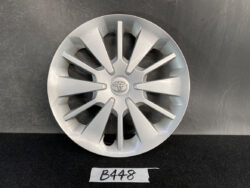 Silver Toyota hubcap with a multi-spoke design displayed against a dark background