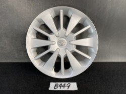 Silver Toyota alloy wheel cover with many angular spokes and a Toyota emblem in the center, displayed against a dark background.