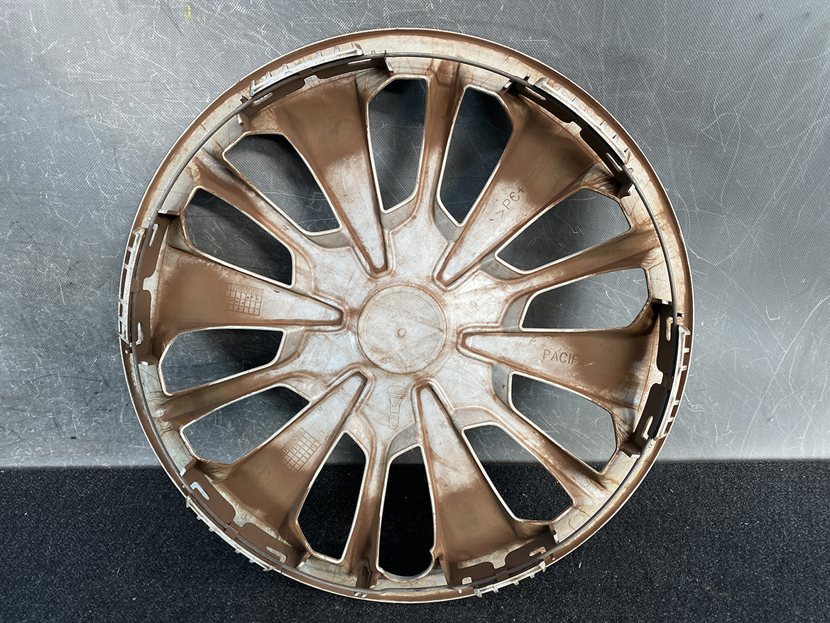 B449_3 TOYOTA PASSO M700A Genuine 14inch WHEEL CAP / HUB CAP x1 » NZ.95 » JDM-PARTS NZ » JDM-PARTS NZ Dusty brown plastic car wheel hubcap with many spokes, laid flat on a dark surface. TOYOTA PASSO M700A Genuine 14inch WHEEL CAP / HUB CAP x1 » JDM-PARTS NZ