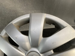 Cracked silver alloy wheel with visible fractures and scratches