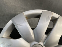 Close-up of a silver alloy wheel with multiple surface scratches and a few rust spots.