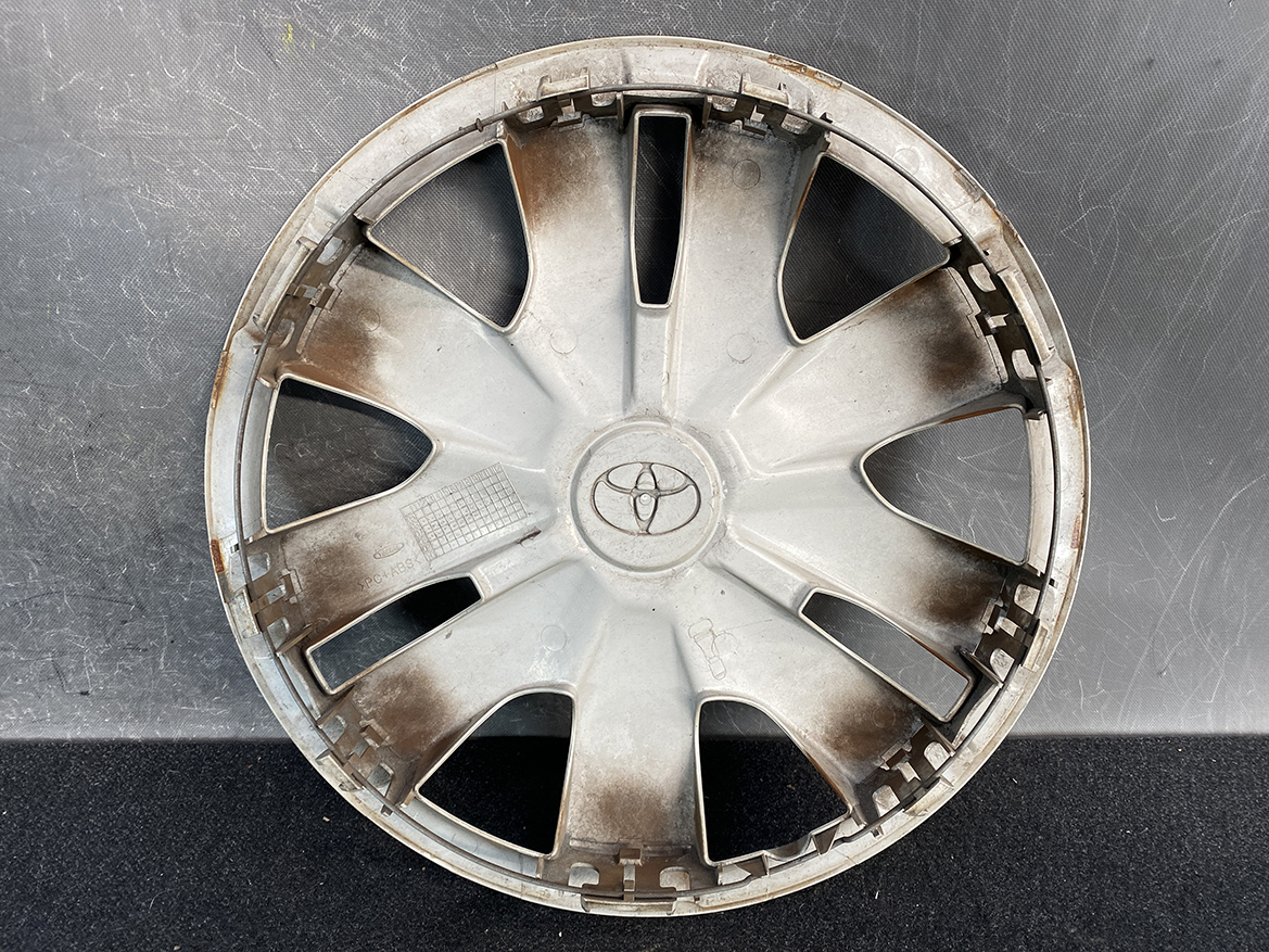B454_3 TOYOTA BELTA SCP92 NCP96 KSP92 Genuine 14inch WHEEL CAP / HUB CAP x1 » NZ.95 » JDM-PARTS NZ » JDM-PARTS NZ Gray Toyota hubcap with radial spokes, dirty and rust-stained, on a dark surface as a wheel cover fixture. TOYOTA BELTA SCP92 NCP96 KSP92 Genuine 14inch WHEEL CAP / HUB CAP x1 » JDM-PARTS NZ