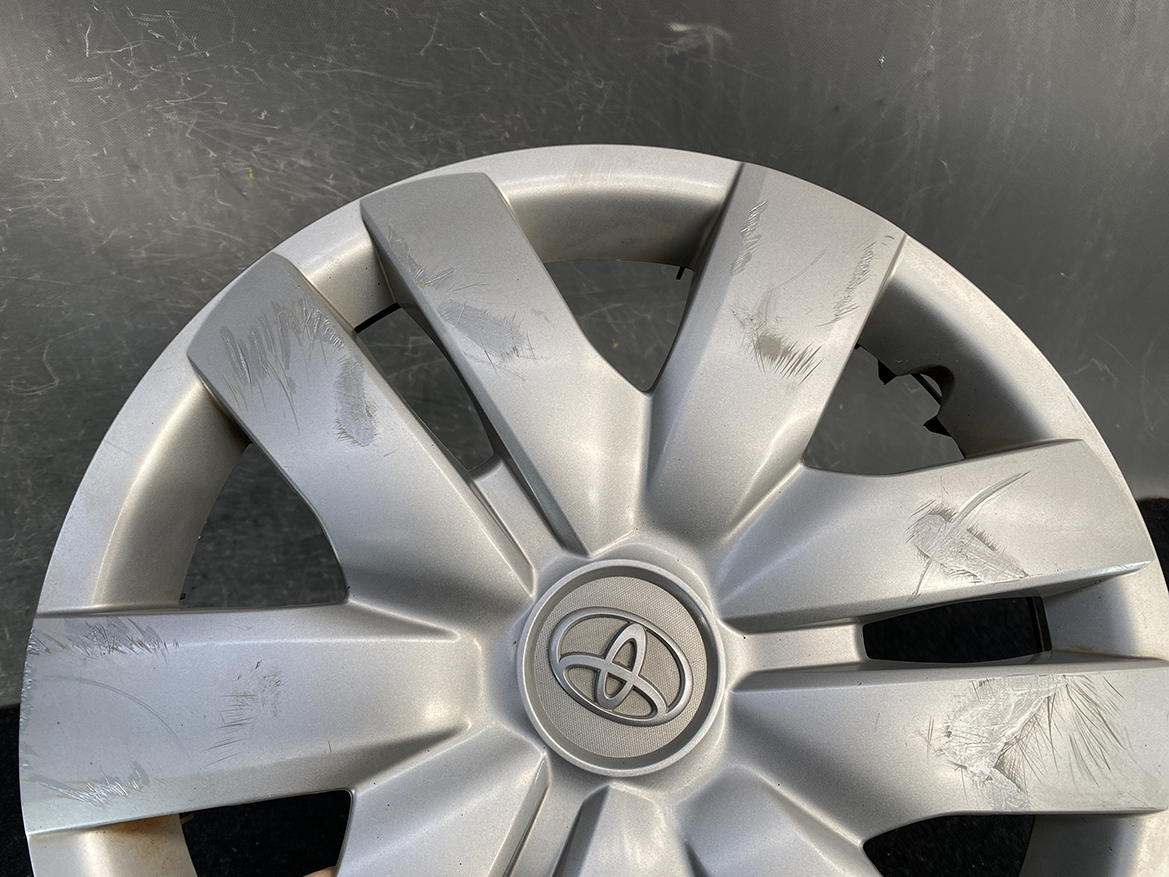 B454_4 TOYOTA BELTA SCP92 NCP96 KSP92 Genuine 14inch WHEEL CAP / HUB CAP x1 » NZ.95 » JDM-PARTS NZ » JDM-PARTS NZ Silver Toyota hubcap with multiple surface scratches and scuffs on the spokes around the logo area TOYOTA BELTA SCP92 NCP96 KSP92 Genuine 14inch WHEEL CAP / HUB CAP x1 » JDM-PARTS NZ