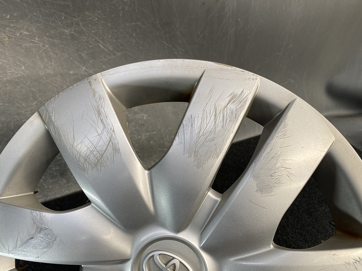 B454_5 TOYOTA BELTA SCP92 NCP96 KSP92 Genuine 14inch WHEEL CAP / HUB CAP x1 » NZ.95 » JDM-PARTS NZ » JDM-PARTS NZ Alloy wheel with multiple surface scratches and scuffs around several spokes, center cap visible with logo partially shown. TOYOTA BELTA SCP92 NCP96 KSP92 Genuine 14inch WHEEL CAP / HUB CAP x1 » JDM-PARTS NZ