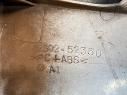 Close-up of a molded plastic part showing part number 42602-52350 and material PC+ABS (A1).