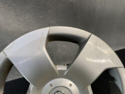 Close-up of a silver car steering wheel center with a few scratches and scuffs near the horn button area.