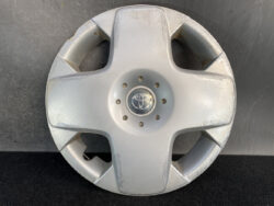 Silver Toyota hubcap with center emblem and circular lug nut holes, showing surface scratches and wear.