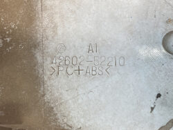 Close-up of a stamped part showing A1, 42602-52210, and the material mark >PVC+ABS