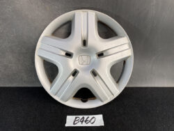 Silver Honda hubcap with five split spokes and the Honda emblem in the center on a dark background.