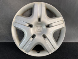 Silver Honda hubcap with a five-spoke star design and minor scratches on the right side, centered Honda logo in the middle.