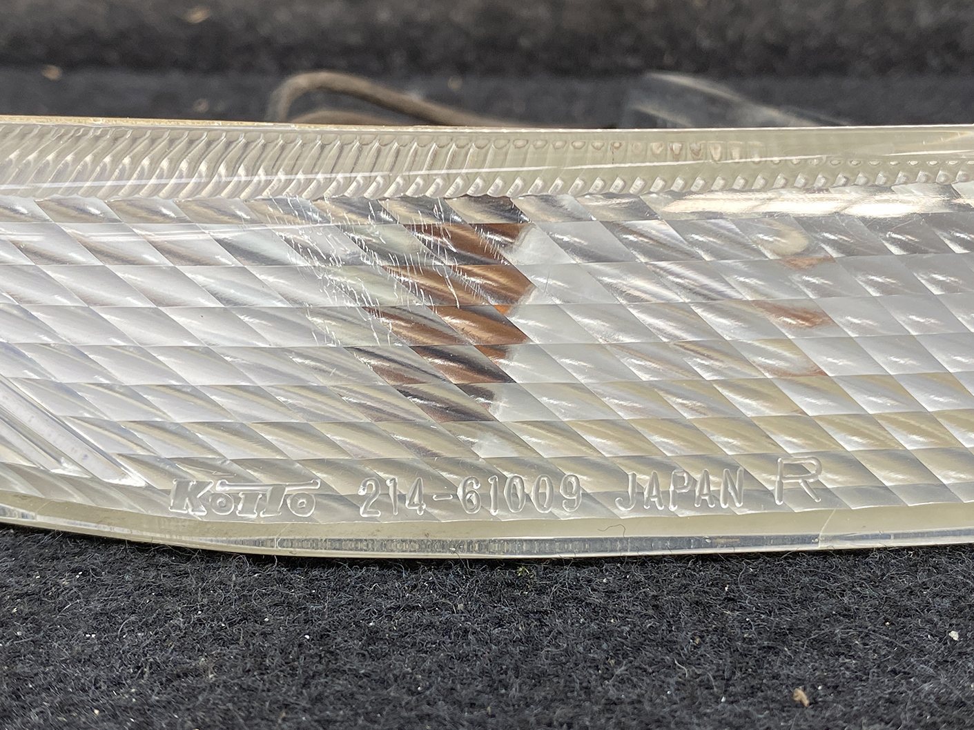 B463_3 MAZDA RX-8 SE3P Genuine Side Indicator KOITO 214-61009 Right Side x1 » NZ.95 » JDM-PARTS NZ » JDM-PARTS NZ Close-up of a clear car tail light lens with a diagonal facet pattern and 'JAPAN R' engraving. MAZDA RX-8 SE3P Genuine Side Indicator KOITO 214-61009 Right Side x1 » JDM-PARTS NZ