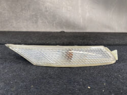 Translucent car side marker/turn-signal lens with a diamond-cut pattern, placed on a dark surface