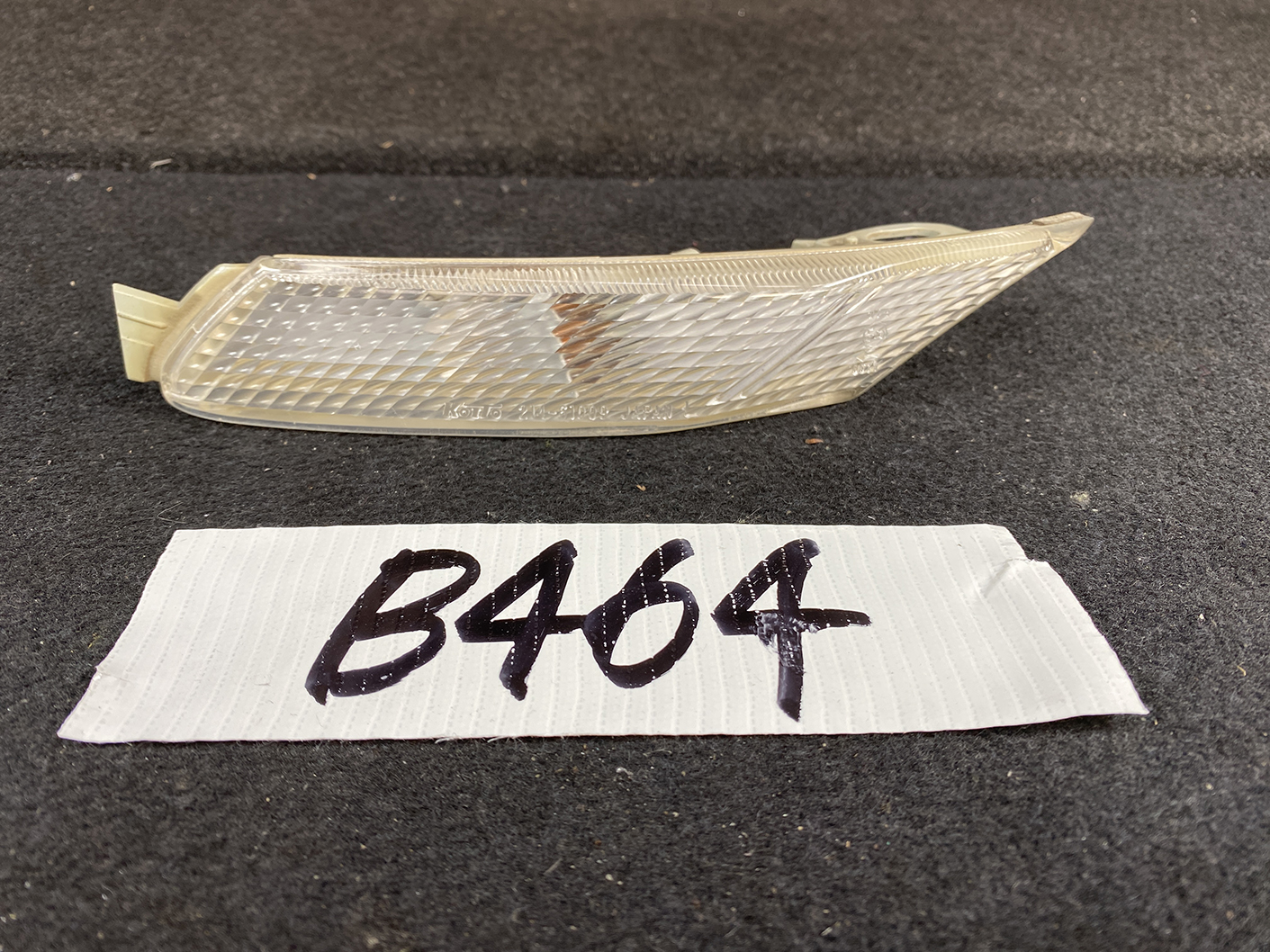 B464_1 MAZDA RX-8 SE3P Genuine Side Indicator KOITO 214-61009 Left Side x1 » NZ.95 » JDM-PARTS NZ » JDM-PARTS NZ Clear car side marker/turn signal lens with a diamond-pattern surface, labeled B464 on a white tag placed beneath it MAZDA RX-8 SE3P Genuine Side Indicator KOITO 214-61009 Left Side x1 » JDM-PARTS NZ