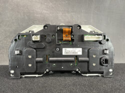 Back view of a car instrument cluster module showing connectors, circuit boards, and an orange ribbon cable.