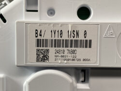 Close-up of a white electrical device label showing a barcode, a QR code, and the text B4/ 1Y10 11SN 0 with additional numeric lines underneath.