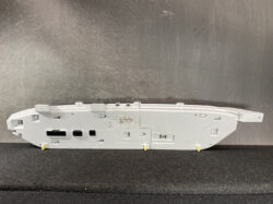 Rear view of a light-gray Nissan instrument cluster housing with multiple connector slots and mounting tabs