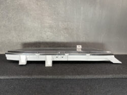 Automotive sunroof assembly with glass panel and mounting frame on a dark surface.