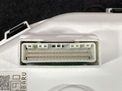 White automotive multi-pin electrical connector with gold pins, mounted in a white housing on a device edge